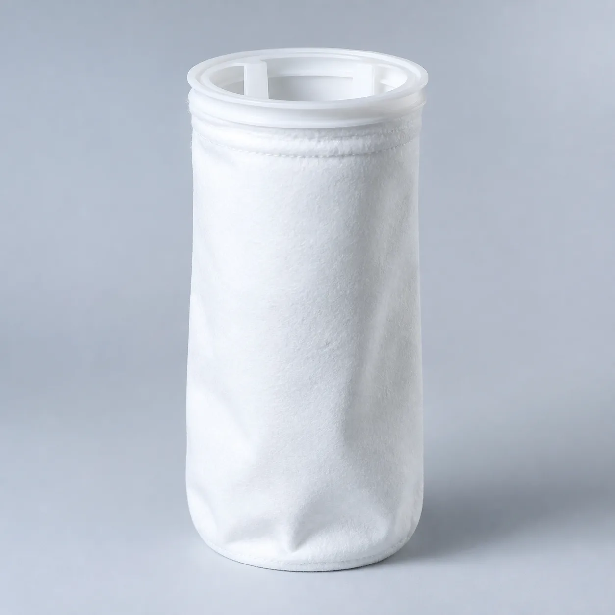 Liquid filter bag with plastic sealing ring for bag filter housings